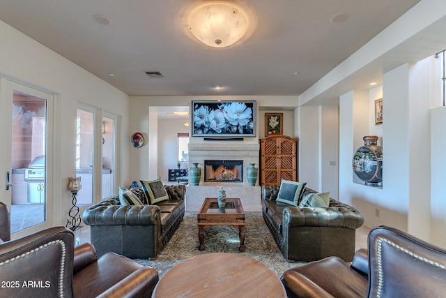 living area with a premium fireplace and visible vents