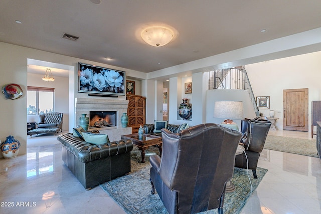 living room with a high end fireplace and visible vents