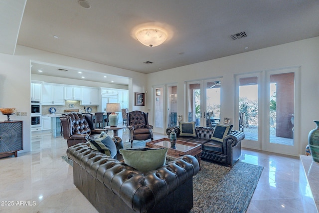 living room featuring marble finish floor, visible vents, and french doors