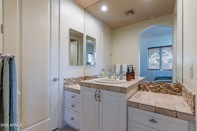 bathroom with recessed lighting, visible vents, decorative backsplash, ensuite bathroom, and vanity