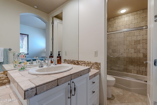 full bathroom featuring shower / bath combination with glass door, vanity, and toilet