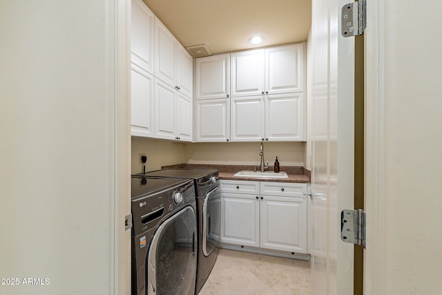 laundry area featuring separate washer and dryer, a sink, and cabinet space