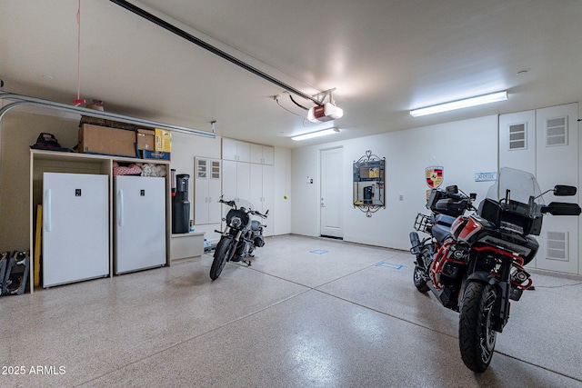 garage featuring freestanding refrigerator and a garage door opener