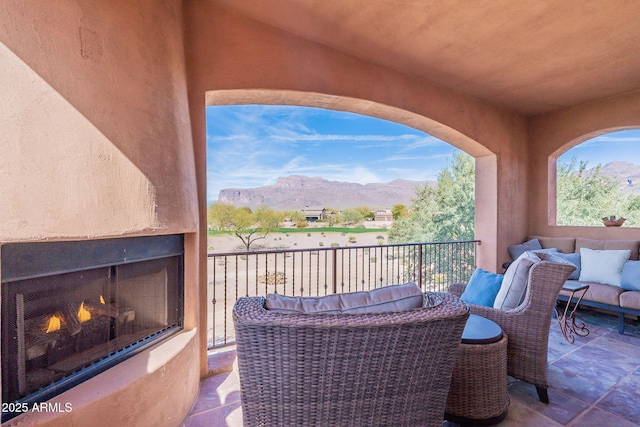 exterior space with a mountain view and an outdoor living space with a fireplace