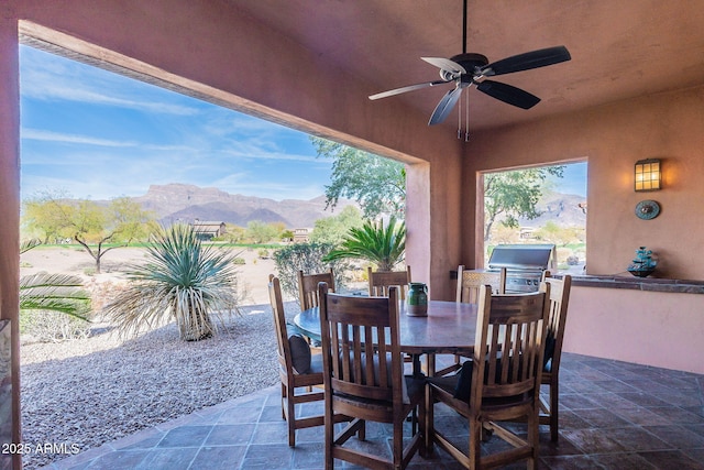 view of patio / terrace featuring ceiling fan, a mountain view, and outdoor dining space