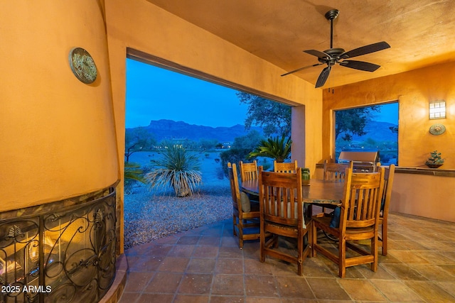 view of patio / terrace with a mountain view, a ceiling fan, and outdoor dining space