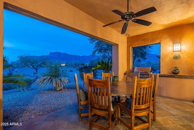 view of patio featuring a mountain view, outdoor dining space, and a ceiling fan