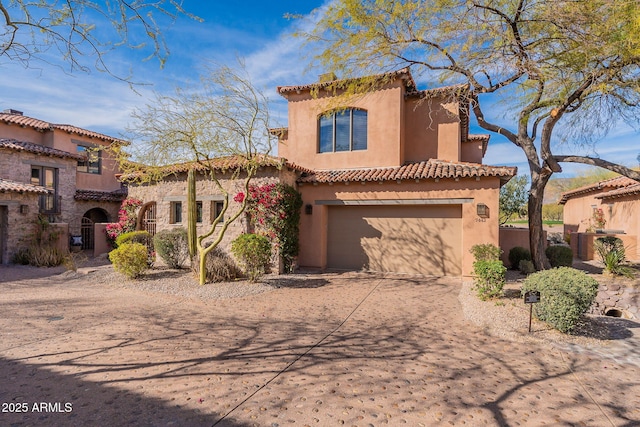 mediterranean / spanish home with driveway, an attached garage, and stucco siding