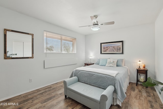 bedroom featuring a ceiling fan, baseboards, and wood finished floors