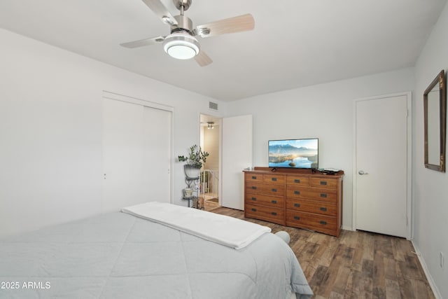 bedroom featuring ceiling fan, visible vents, and wood finished floors