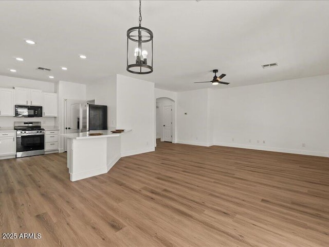 271 W Roadrunner Dr, Chandler, AZ 85286 - kitchen with light wood-style floors, arched walkways, a ceiling fan, and stainless steel appliances