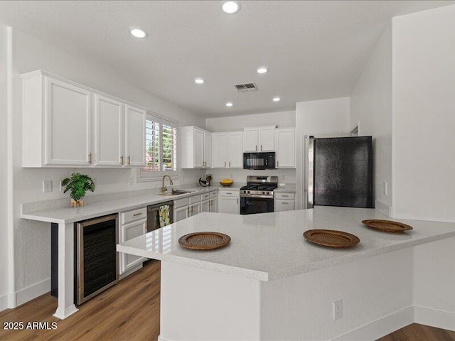 271 W Roadrunner Dr, Chandler, AZ 85286 - kitchen with black microwave, a sink, stainless steel range with gas cooktop, freestanding refrigerator, and wine cooler