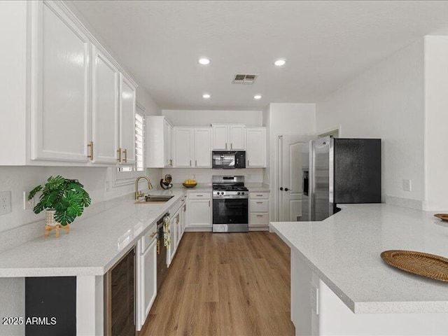 271 W Roadrunner Dr, Chandler, AZ 85286 - kitchen featuring visible vents, light wood-type flooring, a sink, stainless steel appliances, and white cabinetry