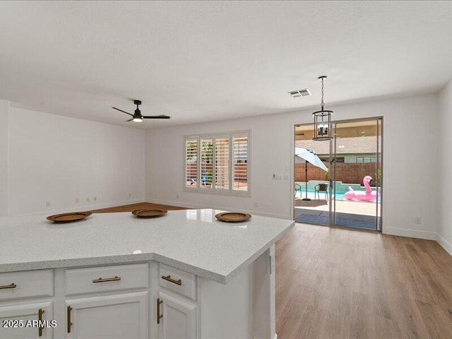 271 W Roadrunner Dr, Chandler, AZ 85286 - kitchen with a ceiling fan, visible vents, light wood-type flooring, light countertops, and white cabinets