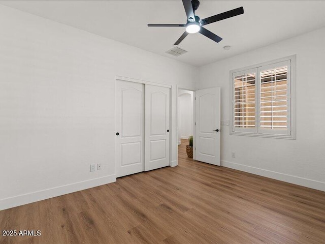 271 W Roadrunner Dr, Chandler, AZ 85286 - unfurnished bedroom featuring ceiling fan, baseboards, wood finished floors, visible vents, and a closet