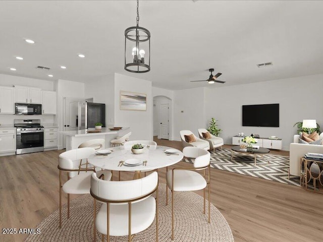 271 W Roadrunner Dr, Chandler, AZ 85286 - dining space with light wood-style floors, arched walkways, ceiling fan, and visible vents