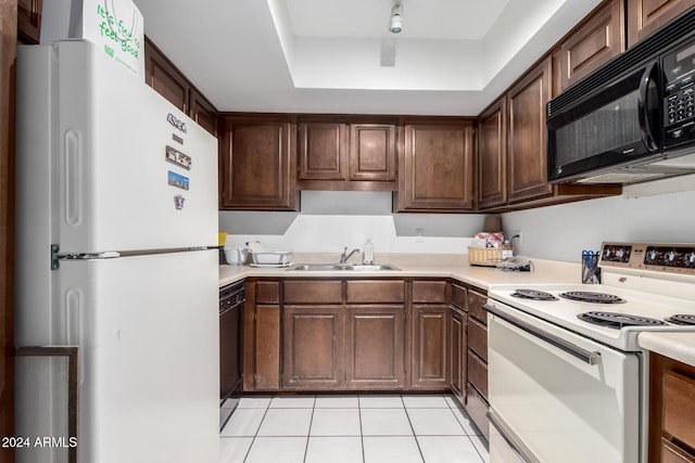 kitchen with light tile patterned flooring, sink, dark brown cabinetry, and black appliances