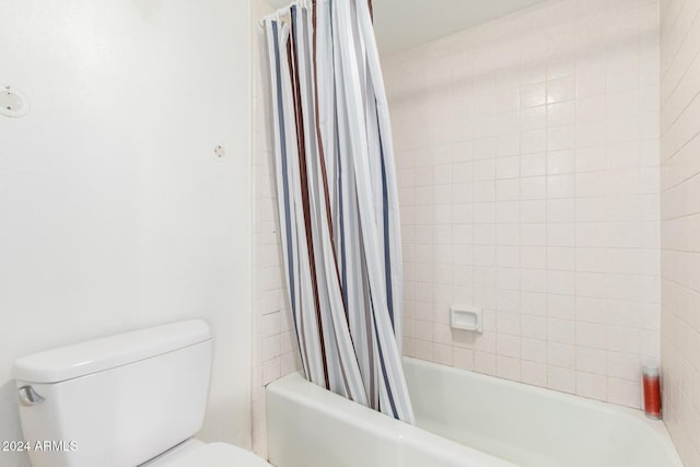 bathroom with shower / bath combo with shower curtain and toilet