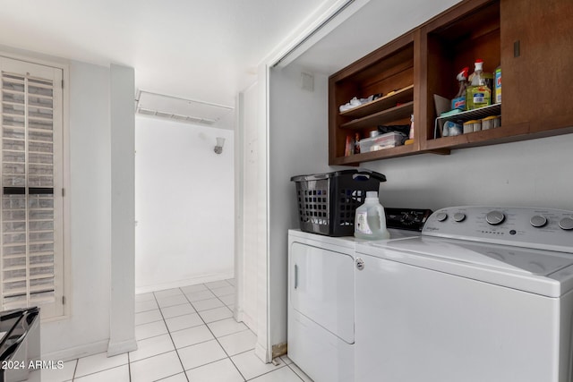 clothes washing area featuring light tile patterned floors and washer and clothes dryer