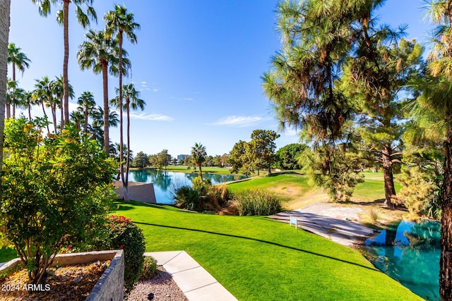 view of property's community with a yard and a water view