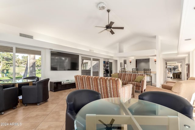 dining room with ceiling fan, light tile patterned floors, and vaulted ceiling