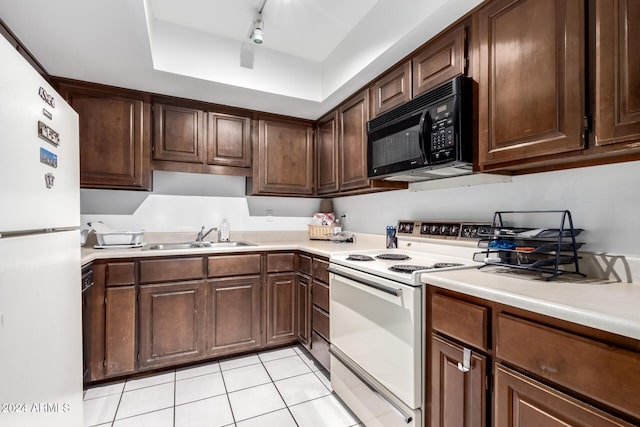 kitchen with track lighting, dark brown cabinets, white appliances, sink, and light tile patterned flooring