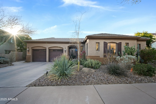 view of front of property with an attached garage, concrete driveway, and stucco siding