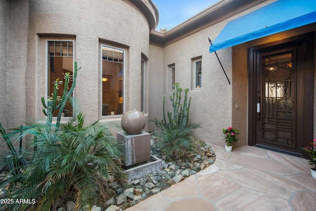 doorway to property featuring stucco siding