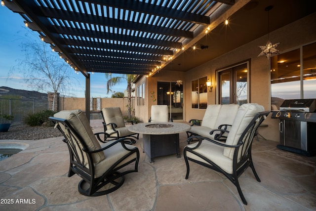 patio terrace at dusk with an outdoor living space with a fire pit, grilling area, a fenced backyard, and a pergola