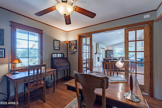 office space featuring a ceiling fan, baseboards, wood finished floors, lofted ceiling, and ornamental molding