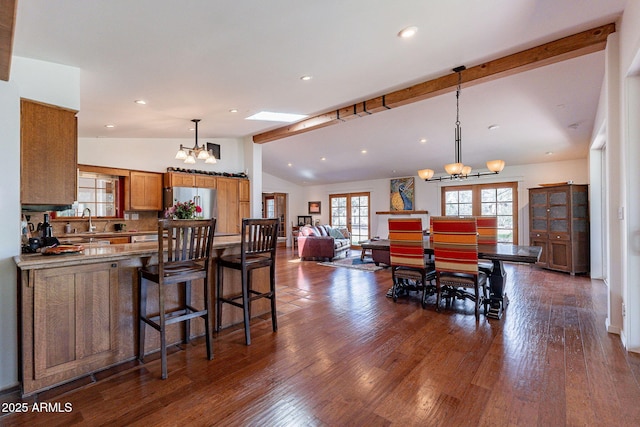 dining area with recessed lighting, vaulted ceiling with beams, dark wood finished floors, and a notable chandelier