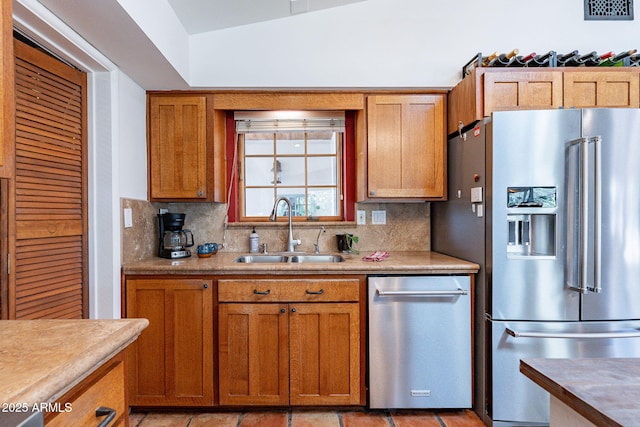 kitchen with decorative backsplash, light countertops, brown cabinets, a sink, and stainless steel appliances