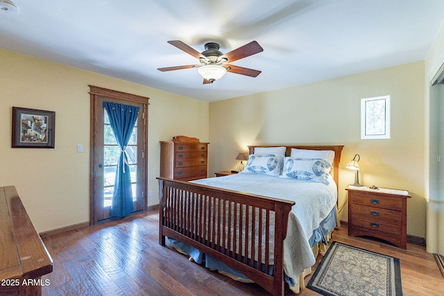 bedroom featuring access to outside, a ceiling fan, baseboards, and wood finished floors