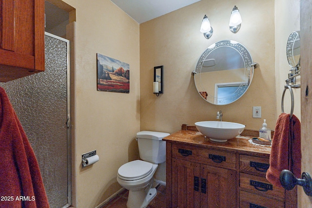 bathroom featuring vanity, baseboards, a stall shower, and toilet