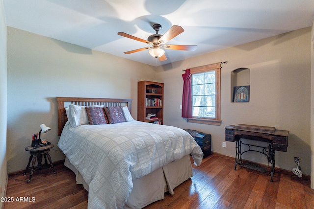 bedroom featuring a ceiling fan, baseboards, and wood finished floors
