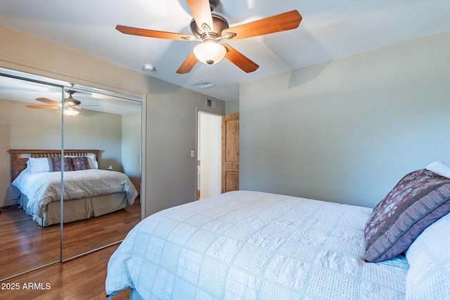 bedroom featuring visible vents, a ceiling fan, wood finished floors, and a closet