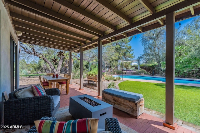 view of patio with a fire pit, an outdoor pool, and outdoor dining space