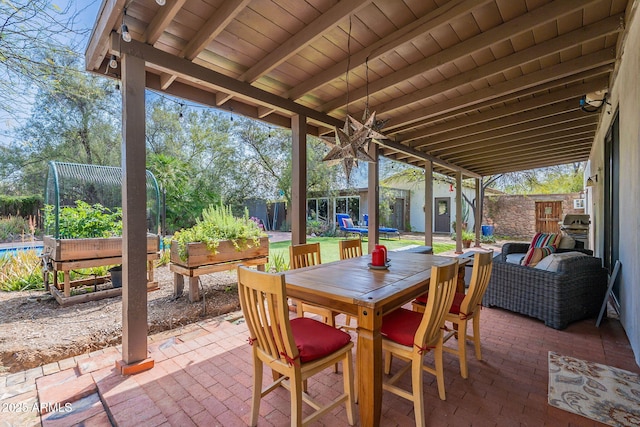 view of patio / terrace with a fenced backyard, a trampoline, outdoor dining area, and a vegetable garden