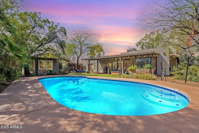 pool at dusk with an outdoor pool