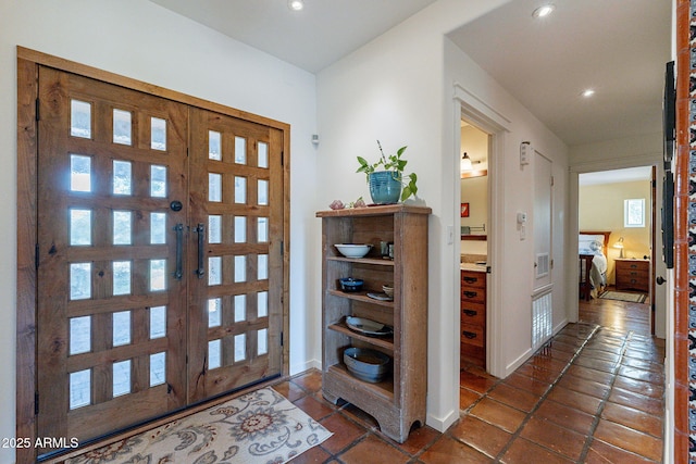 foyer featuring dark tile patterned flooring, recessed lighting, and plenty of natural light