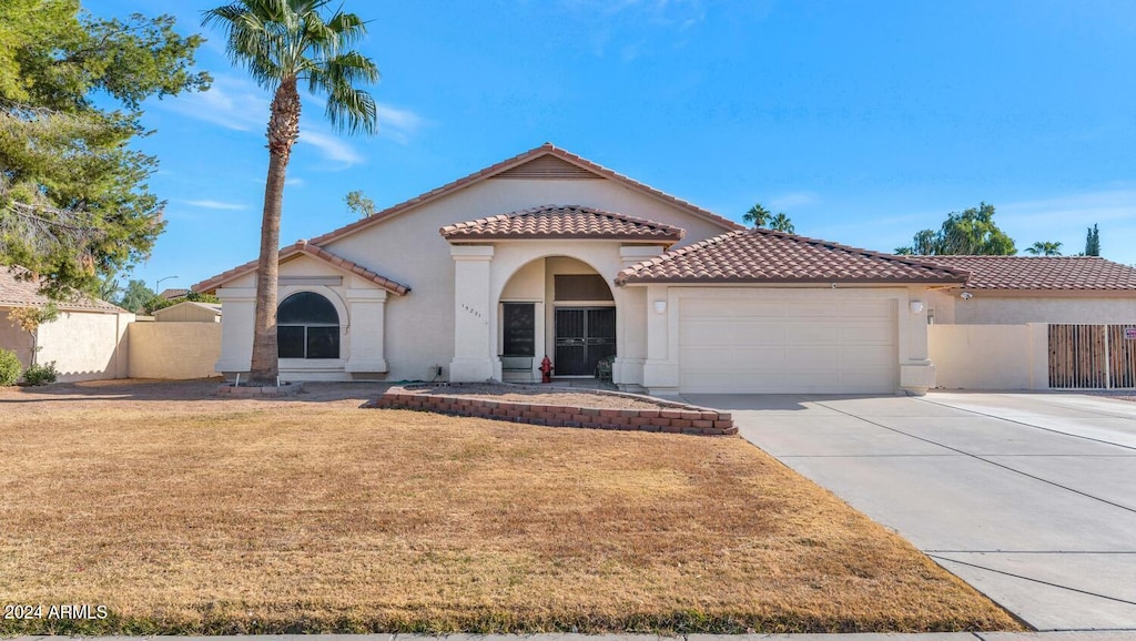 mediterranean / spanish-style home featuring a garage and a front yard