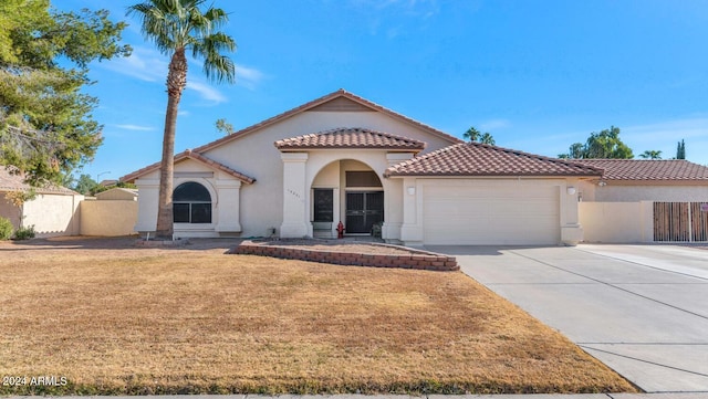 mediterranean / spanish-style home featuring a garage and a front yard