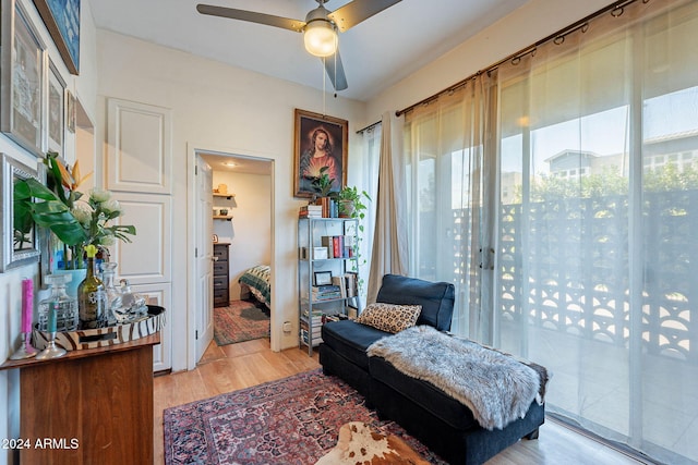 living area featuring light hardwood / wood-style flooring and ceiling fan