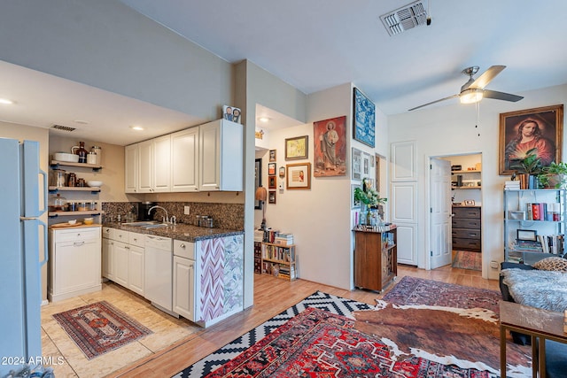 kitchen with white cabinetry, sink, white appliances, and light wood-type flooring