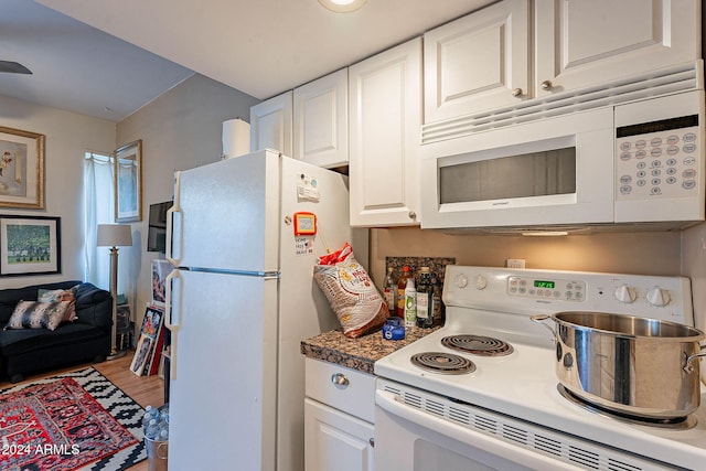 kitchen with hardwood / wood-style floors, white cabinetry, and white appliances