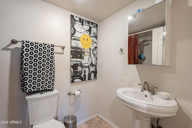 bathroom with sink, a shower with shower curtain, and toilet