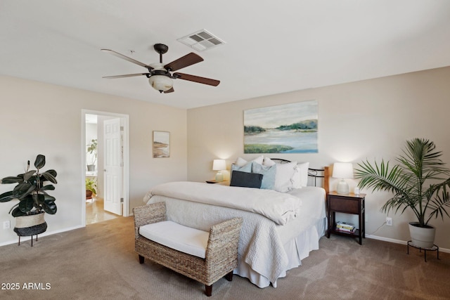 bedroom with carpet floors, ceiling fan, and ensuite bath