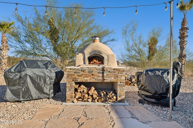 view of patio / terrace featuring a grill and an outdoor stone fireplace