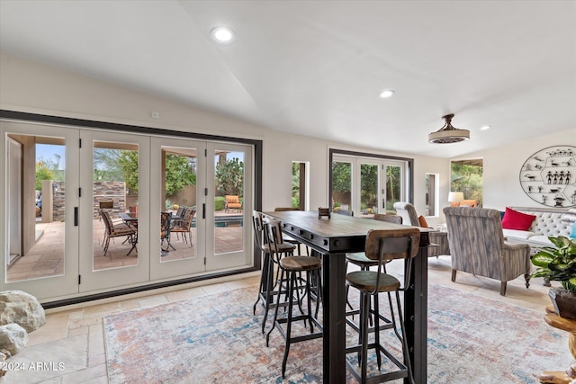 dining space featuring vaulted ceiling and french doors