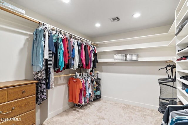 walk in closet featuring light colored carpet